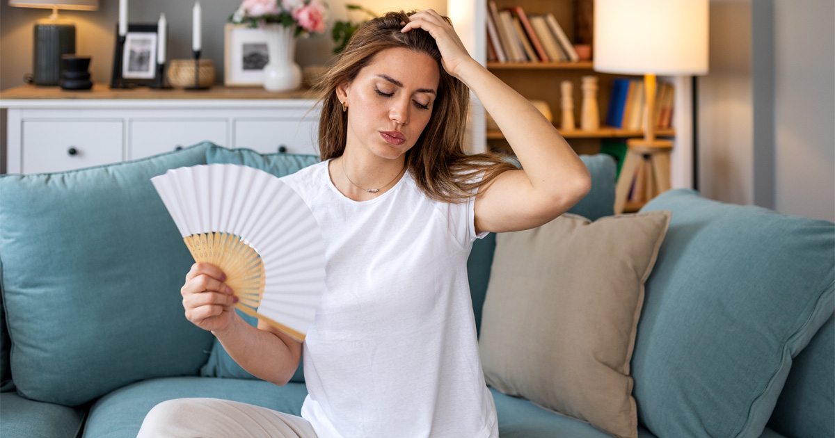 Woman experiencing hot flashes and night sweats in women during menopause symptoms