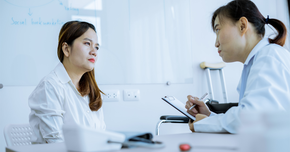 Woman learning about low estrogen symptoms and hormone health during a medical consultation.